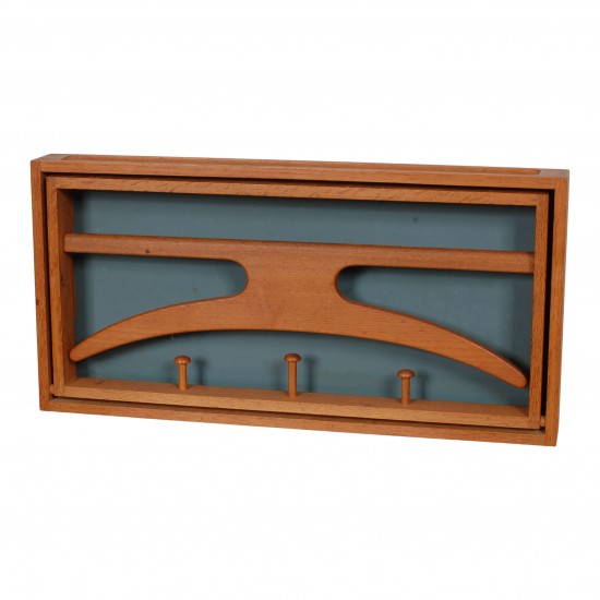 Adam Hoff and Poul Østergaard foldable hanger/coat rack, teak with a background of blue formica