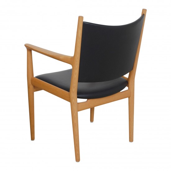 Hans J Wegner Armstol model JH 713, i sort læder og stel af eg